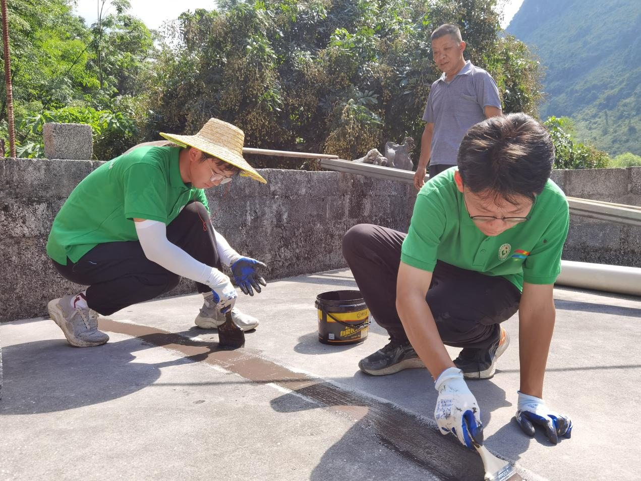 实践团成员在裂缝处涂抹防水涂料4.png