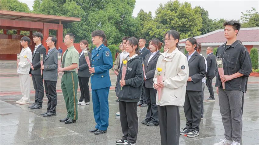 同学们整齐列队肃立在烈士纪念碑前默哀致敬。