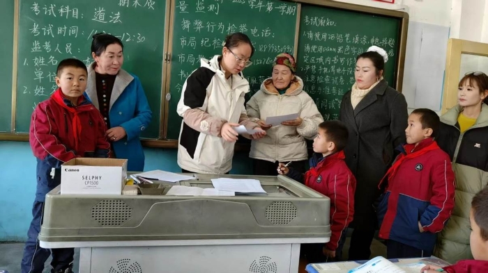 图片5：西部计划志愿者王艺枝与谢依特小学学生和家长进行成绩分析